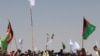 FILE: Supporters of the Taliban and Afghan government wave their respective flags during a cease-fire in June 2018.