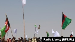 FILE: Supporters of the Taliban and Afghan government wave their respective flags during a cease-fire in June 2018.