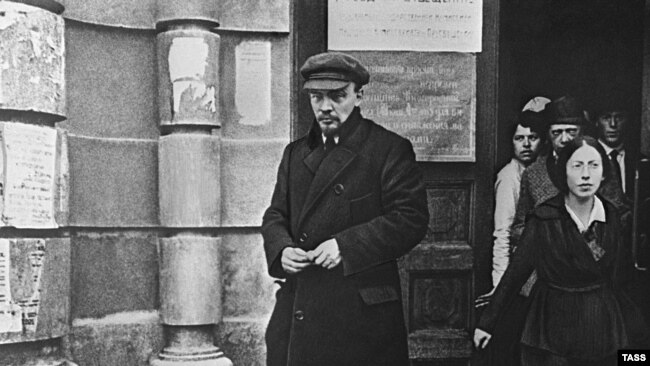 Ленин, с каскета на главата, придружен от Надежда Крупская