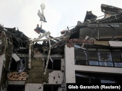 Spasioci se spuštaju u stambenu zgradu uništenu u raketnim napadima ruskih snaga, Kijev, 26. jun 2022.