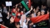 Women and children, mostly Libyans, gather outside the Libyan Embassy in Tunis on August 21, where the insurgents' flag was hoisted on the roof of the building.