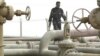 An Iraqi security guard walks along a pipeline at a refinery near the Umm Qasr port in the southern city of Basra.