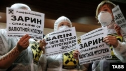 Protesters hold placards during a rally by foreign-currency mortgage holders at Raiffeisen Bank in Moscow in February last year. 