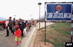 Албанці-косовари пішки переходять кордон, тікаючи з Югославії до Албанії. 1 квітня 1999 року