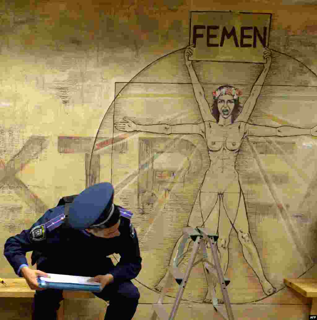 Ukrainian police search the premises of the feminist movement Femen in Kyiv. Police say they found a gun, a grenade, and portraits of Russian President Vladimir Putin and Patriarch Kirill. Anna Hutsol, leader of the organization, says it was a provocation organized by the security services against the activists of the organization. (AFP/Sergei Supinsky)