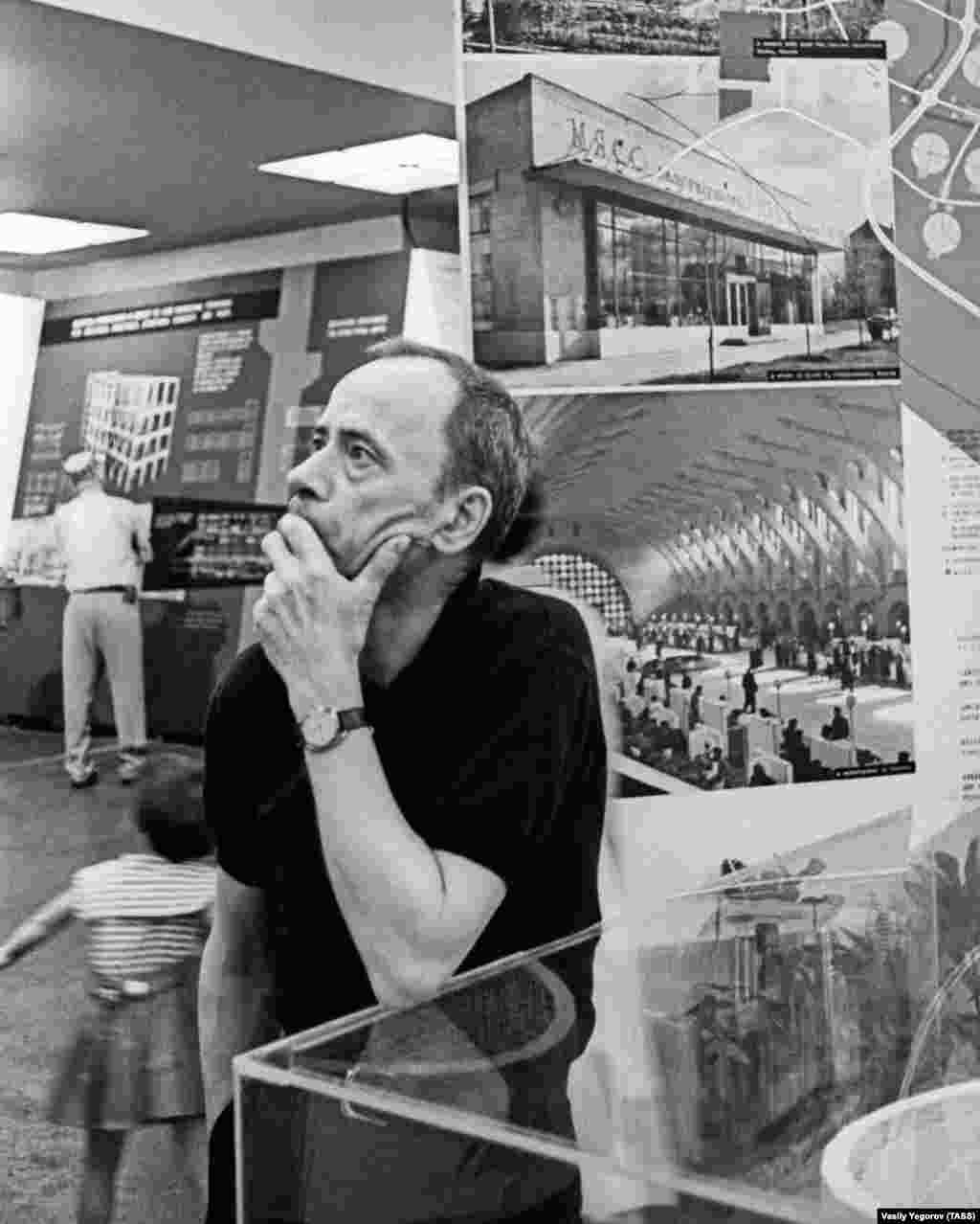 A visitor to the exhibition in front of photos from the Soviet Union. While ostensibly intended to bring the two countries closer, comments in guestbooks left around the exhibition hall were largely negative and reveal the hostilities (and odd humor) of the time. After watching a performance of folk music, one visitor reportedly scribbled, &ldquo;Russian music is for the birds, if they&rsquo;ll take it.&rdquo; &nbsp;