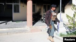 An Afghan policeman outside the government district building after a Taliban attack in the Khawaja Omari district of Ghazni Province on April 12.