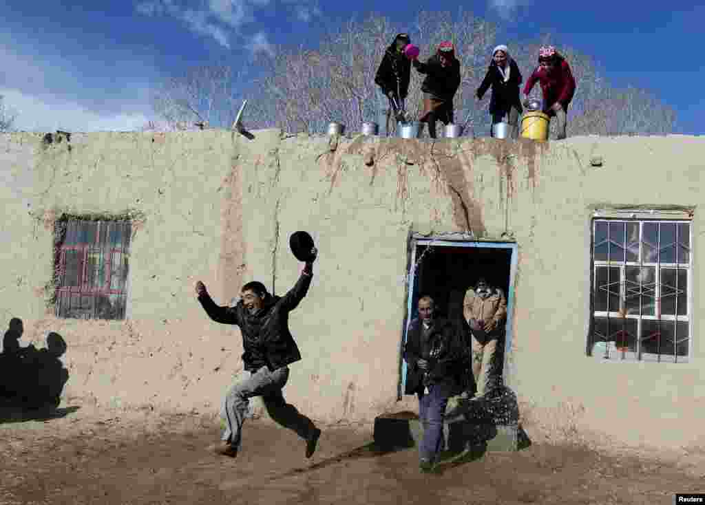 Women throw water on men from a rooftop as they take part celebrations to welcome the coming of spring in China's Xinjiang Uighur Autonomous Region on March 18. (Reuters)