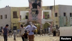 People gather at site of a deadly suicide in the Yemeni port city of Aden. 