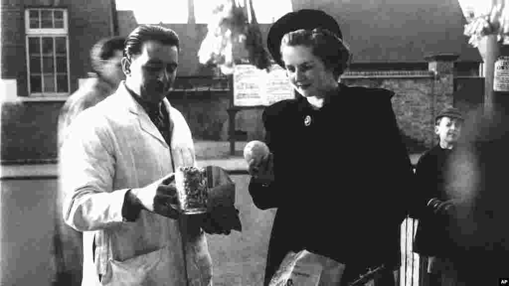 Маргарет Робертс (позже премьер-министр Великобритании Маргарет Тэтчер) покупает арахис и фрукты в Кенте, 1950 год.