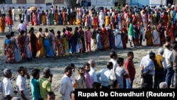 Voters line up to cast their votes outside a polling station during the first phase of general election in Alipurduar district in the eastern state of West Bengal on April 11.
