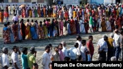 Voters line up to cast their votes outside a polling station during the first phase of general election in Alipurduar district in the eastern state of West Bengal on April 11.