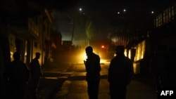 Afghan policemen stand guard at the site of a suicide attack at a foreign guesthouse in Kabul on November 27. 