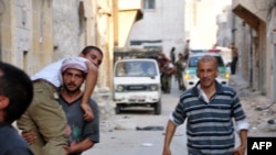 Syria - Syrian rebels assist a comrade during clashes with government troops in the Salhin district of the northern city of Aleppo, 31Jul2012