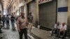 People walk through the old grand bazaar where shops are closed after a protest, in Tehran, Iran, June 25, 2018.