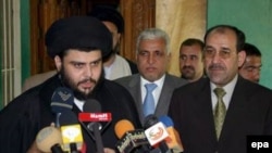 Iraqi Prime Minister Nuri Kamil al-Maliki (right) looks on as Muqtada al-Sadr speaks to the media (file photo)