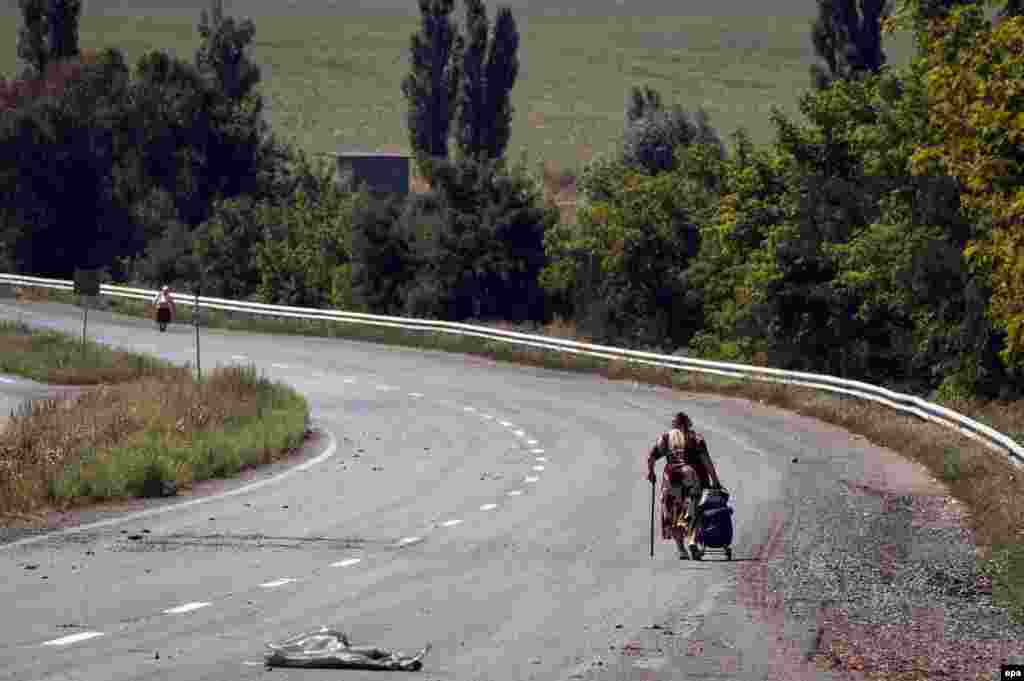 Ukrainian women walk on an empty road not far from the eastern city of Donetsk on August 21. (epa/Roman Pilipey)