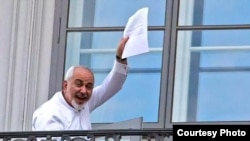 Iranian Foreign Minister Mohammad Javad Zarif waves to reporters from his hotel balcony during the nuclear talks in Vienna on July 13.