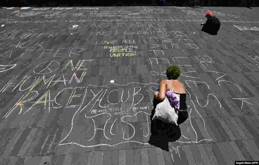A protester writes with chalk during a "Black Trans Lives Matter" march against police brutality on June 17, 2020 in the Brooklyn Borough of New York City.