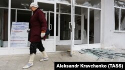 A woman walks past a school building damaged by recent shelling in the city of Donetsk in November.