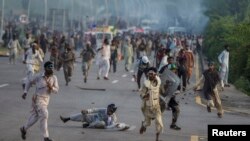 Anti-government protesters run after police personnel in Islamabad, September 1, 2014.