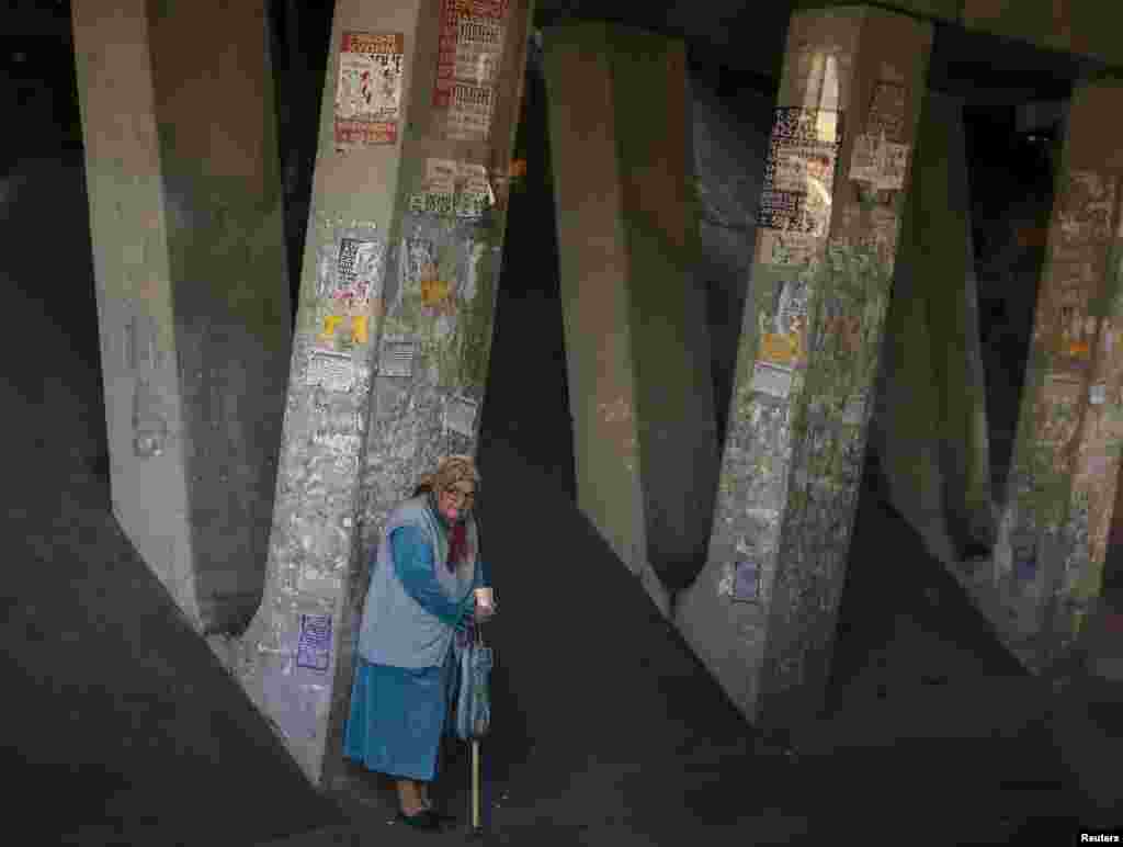 An elderly woman begs under a highway bridge in Kyiv, Ukraine. (Reuters/Gleb Garanich)