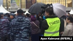 Неизвестные с зонтами мешают снимать видеоператору Азаттыка Тимура Айтмуханбетову. Нур-Султан, 9 июня 2019 года.