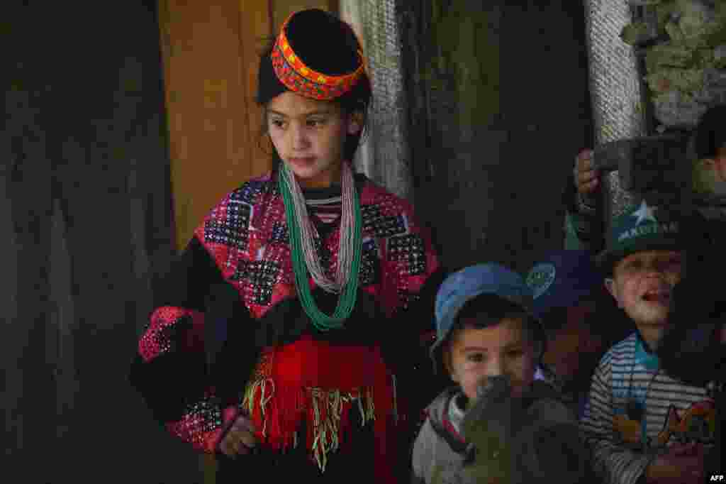 The Kalash are easy to spot. Many wear rings in their hair and sport brightly colored hats. The women sometimes have tattooed faces and wear black robes with colorful embroidery. They speak Kalash, also known as Kalasha, a Dardic language that is a subgroup of the Indo-Aryan languages spoken in northwest Pakistan, in the disputed Himalayan region of Kashmir, and in eastern Afghanistan.