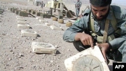 An Afghan policeman points to a mark on a landmine found in Ghurian district in Herat Province (file photo)