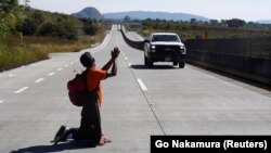 A migrant, part of a caravan of thousands traveling from Central America en route to the United States, attempts to hitchhike on the outskirts of Guadalajara on November 13.