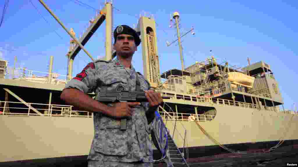 An Iranian soldier stands guard near the Iranian Navy helicopter carrier "Kharg" at Port Sudan on October 31.