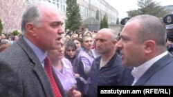 Armenia -- Gloria factory owner Bagrat Darbinian (L) and his employees argue with a police officer trying to prevent its renewed operations, Vanadzor, April 21, 2020.