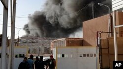 Iraqi security forces secure the site of a fire that broke out at Baghdad's largest ballot box storage site, where ballots from Iraq's May parliamentary elections are stored, in Baghdad, Iraq, Sunday, June 10, 2018. The ballots are part of a manual recoun