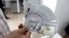 An Iranian man holds U.S. 100-dollar bills at a currency exchange office in a shopping centrer in the capital Tehran, April 10, 2018