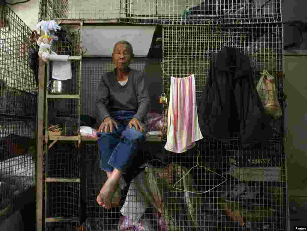 A resident poses in one of Hong Kong&#39;s &quot;cage homes&quot; in 2009.