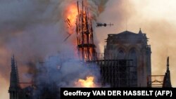 The spire of Notre Dame Cathedral collapses as smoke and flames engulf the iconic building in Paris on April 15. (file photo)