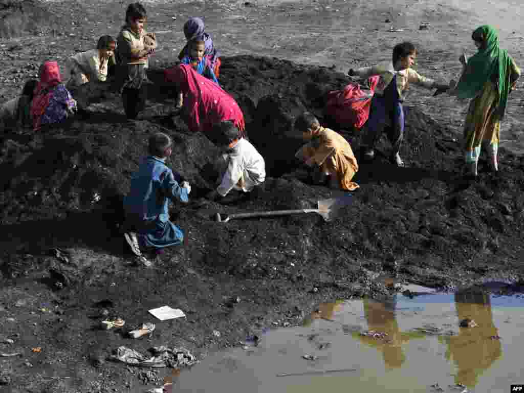 Children search for iron in waste sand in an industrial area of the Pakistani city of Islamabad.