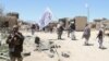 FILE: Suspected Taliban militants patrol after they reportedly took control of Ghazni's Waghaz district in May 2017. 