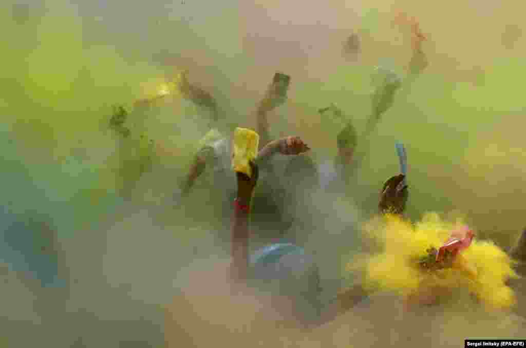 People doused with brightly colored powder and dressed in fancy costumes dance after the 5-kilometer masquerade Color Run at the Luzhniki Olympic complex in Moscow on June 2. (epa-EFE/Sergei Ilnitsky)