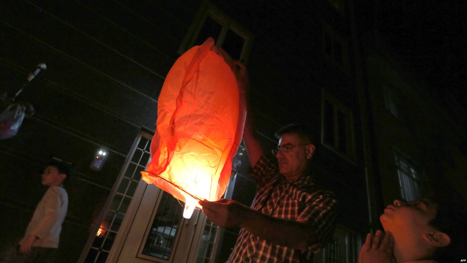 An Iranian man lights a lantern outside their houses in Tehran on March 13, 2018 during the Wednesday Fire feast, or Chaharshanbeh Soori, held annually on the last Wednesday eve before the Spring holiday of Noruz. The Iranian new year that begins on Marc