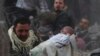 Выжившего ребёнка выносят из разрушенного при авиаударе дома в предместьях Дамаска, 7 января 2014 г. 