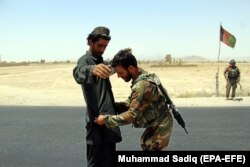 Afghan Army soldiers search people at a checkpoint on a highway leading to the Maiwind district of restive Kandahar province.