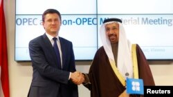 Rusiyanın və Səudiyyənin enerji nazirləri Aleksandr Novak (solda) və Xalid əl-Falih bir-birlərini təbrik edirlər