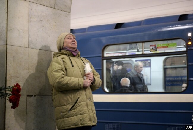 A woman reacts while placing flowers in honor of the victims of the April 3 blast on the platform of the Technological Institute subway station in St. Petersburg on April 4.