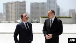 Azerbaijan -- French President Francois Hollande (L) and Azerbaijani President Ilham Aliyev arrive to attend the final cession of the French-Azerbaidjani economic forum on May 12, 2014 at Centre Heydar Aliyev in Baku. 
