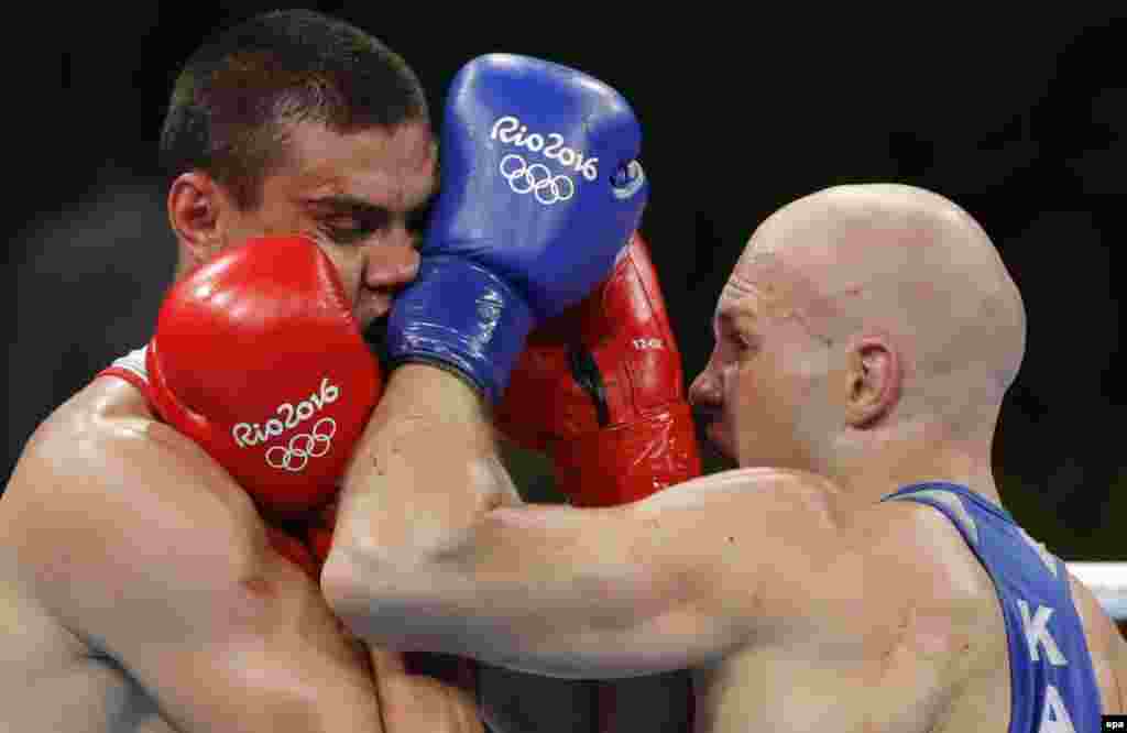Evgeny Tishchenko of Russia (left) and Vassiliy Levit of Kazakhstan box in the men's heavyweight final. The judges awarded Tishchenko the gold in a unanimous decision that was met with booing from the crowd. 