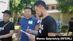 Белсенді Әлнұр Ильяшев (оң жақта) қағаздарды қарап тұр. Алматы, 30 маусым 2019 жыл.