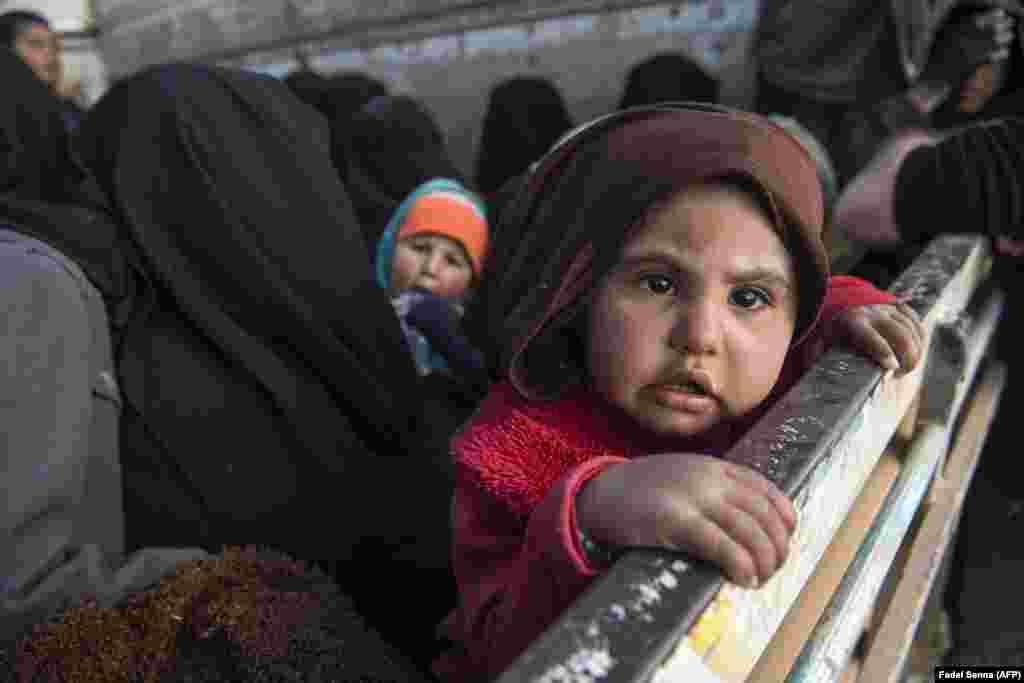 Women and children fleeing from the last Islamic State pocket in Syria sit in the back of a truck near Baghuz, eastern Syria, on February 11. (AFP/Fadel Senna)