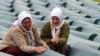 Muslim women weep over a relative's coffin at the Potocari memorial center near Srebrenica in July 2009.