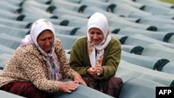 Muslim women weep over a relative's coffin at the Potocari memorial center near Srebrenica in July 2009.